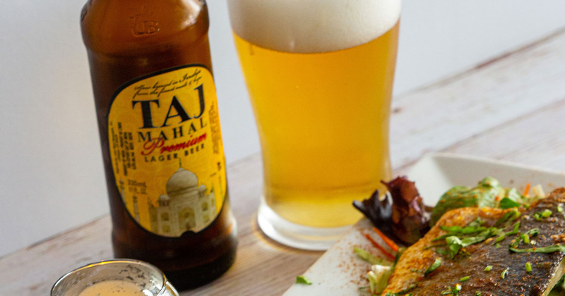 A glass and a bottle of beer