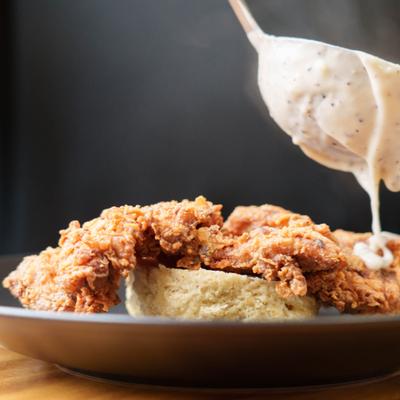 Chicken Biscuits being topped with gravy.