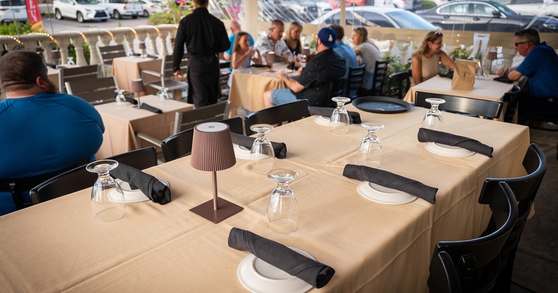 Long dining table set for guests at enclosed patio