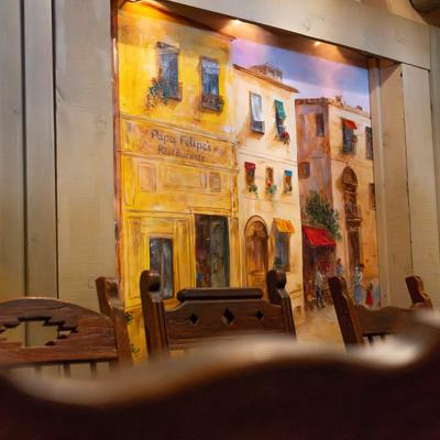 A closeup on chairs and a mural on the wall.