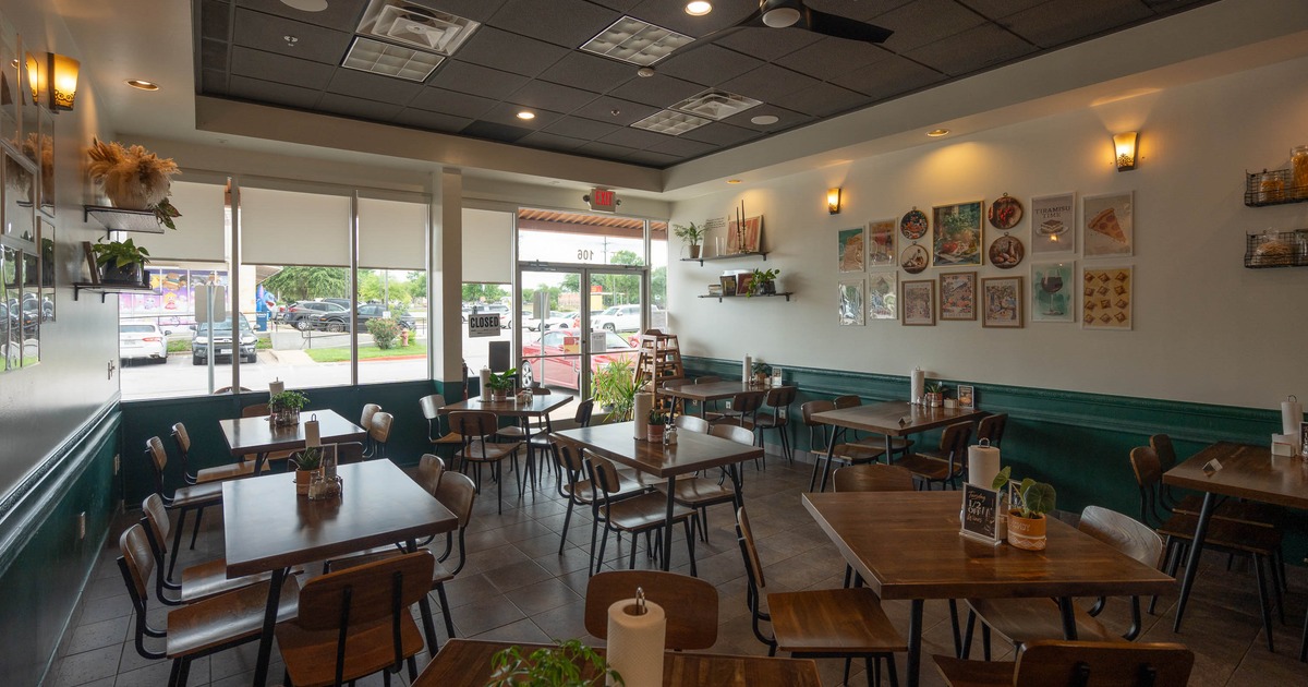Interior - wooden tables & chairs, wall decorations; large windows.