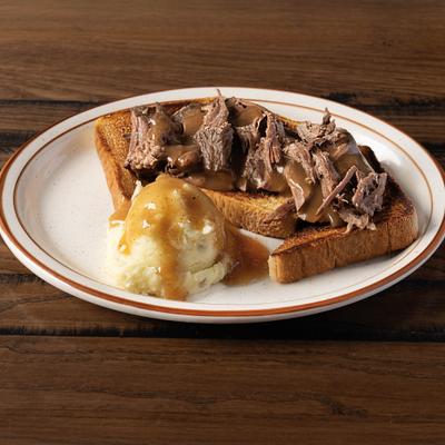 Open-faced roast beef sandwich served with mashed potatoes and gravy.