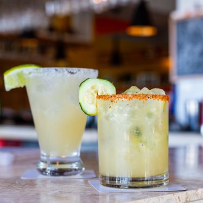 Two margaritas on a marble counter.