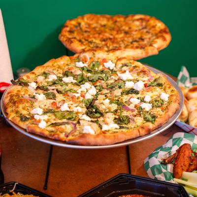 Pesto Supremo Pizza served on the stand alongside a Margherita.
