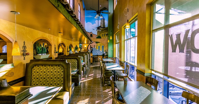 Inside, dining tables and booths next to windows