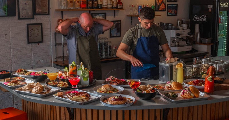 Staff members in action behind a counter with displayed food and drinks
