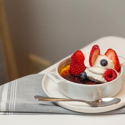Creme brulee topped with whipped cream and fresh berries.