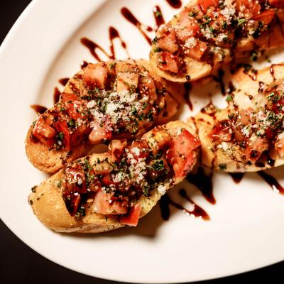 Tomato Bruschetta drizzled with balsasmic glaze, overhead view.