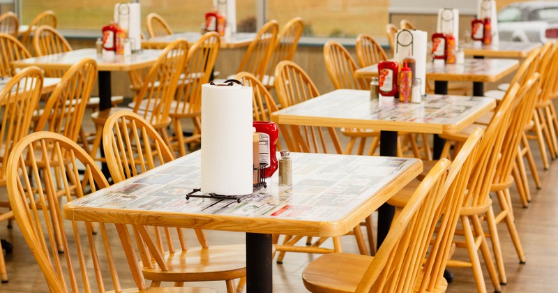 Interior, dining area, closeup on a wooden top table with four wooden chairs