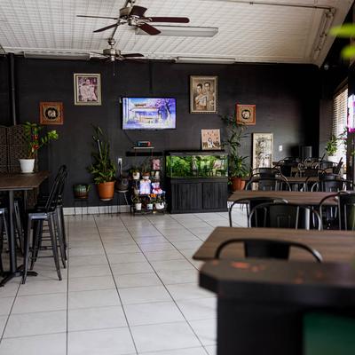Interior with tables, chairs, wall art, and plants.