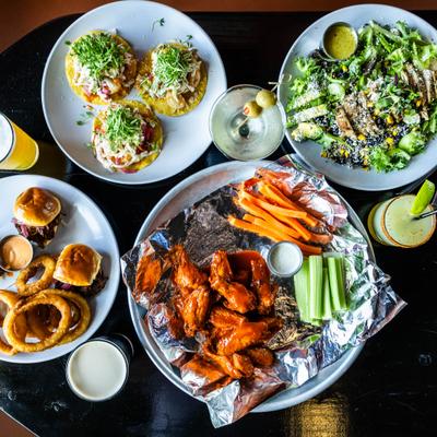 Various dishes served on the table alongside drinks, overhead view.