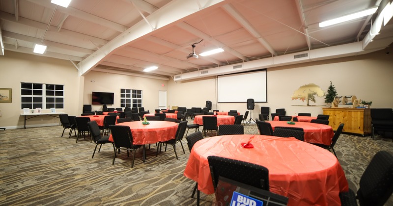 Spacious event hall with round tables, perfect for any special occasion