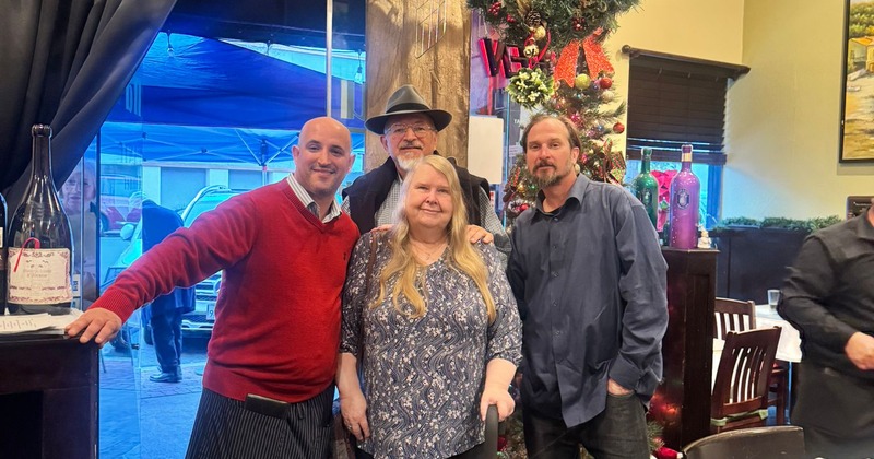 A group of people posing for a picture in a room decorated for Christmas