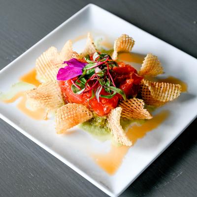 Tuna tartare with chips and colorful garnish.