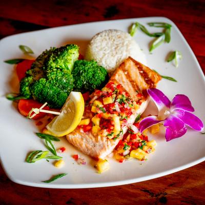 Grilled salmon topped with mango salsa, served with veggies and white rice.