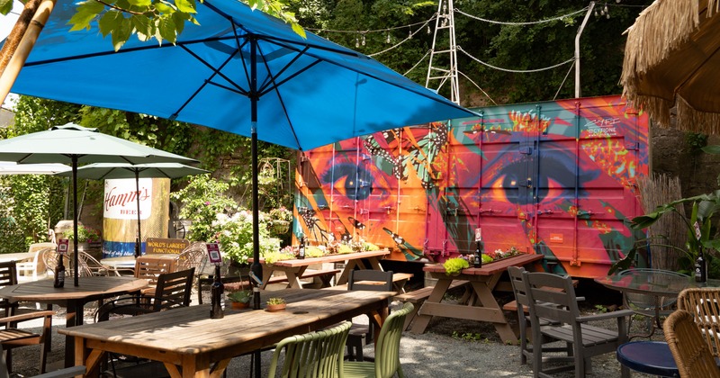 Patio area featuring seating vignettes and mural art on shipping containers