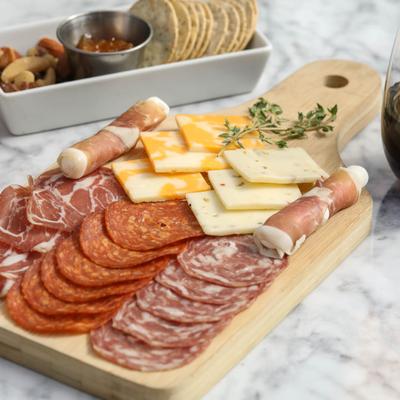 Charcuterie board with nuts, crackers, and red wine.