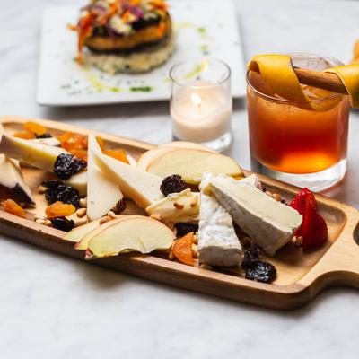 Cheese Platter with drinks and other dishes on a table.