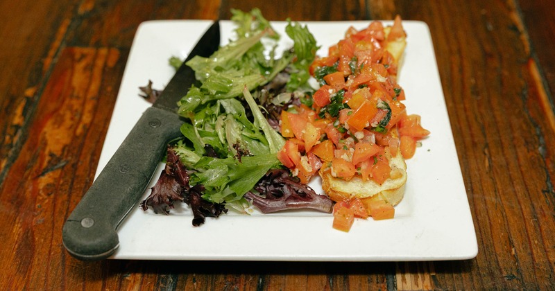Plate of bruschetta served with a side salad