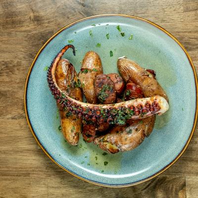 Charred Octopus tentacles served over smashed, roasted potatoes.