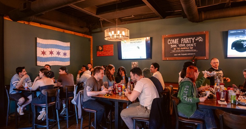 Interior featuring high table seating, TV screens and a flag of Chicago hanging on the wall