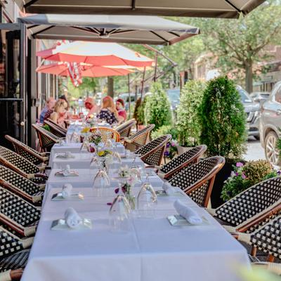 Patio seating with white-tablecloth tables set for service.