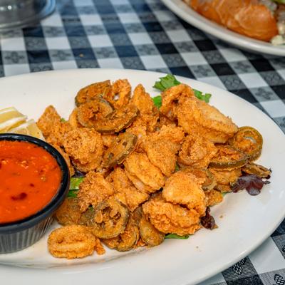 Calamari fritti piled beside marinara sauce.