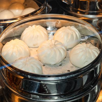 Steamed buns inside a metal steamer basket.