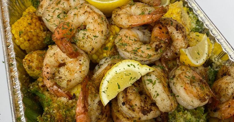 Seasoned shrimp with corn and lemon wedges