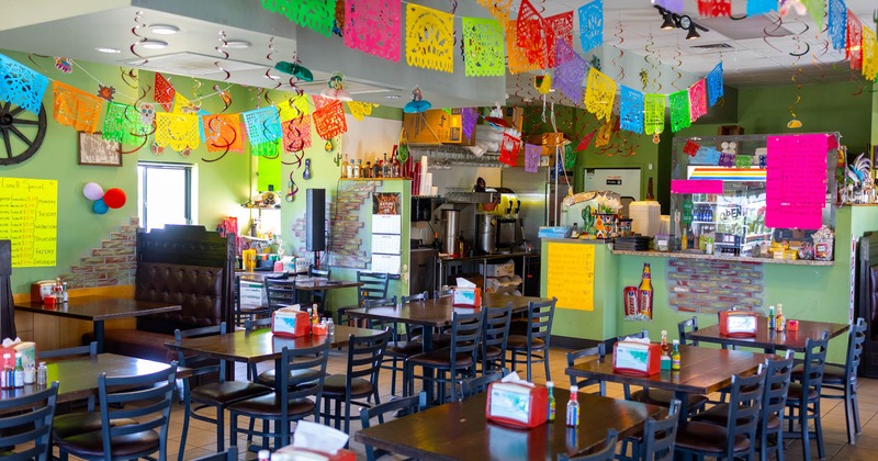 Interior, dining area, tables for four and six people, checkout counter in the back
