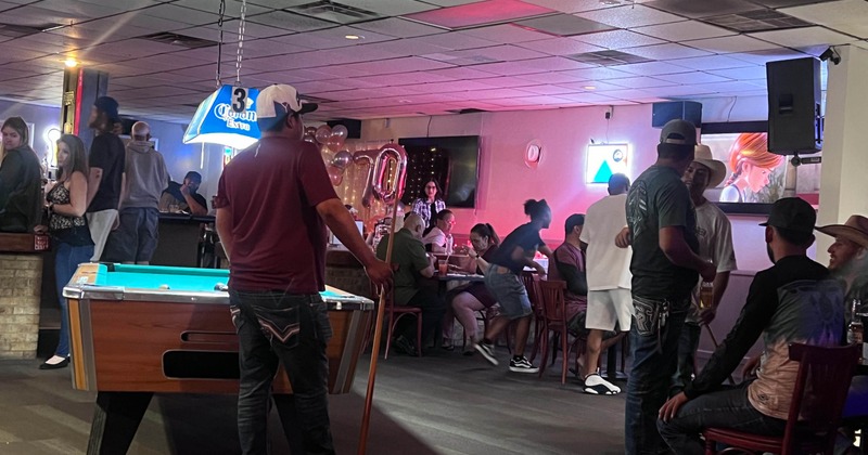 Interior with guests playing pool and seating at tables