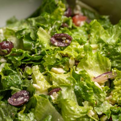 Close up view of greek salad with kalamata olives, red onion, feta cheese, and tomato.