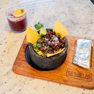 Ribeye Chicharron layered on top guacamole and served with chips.