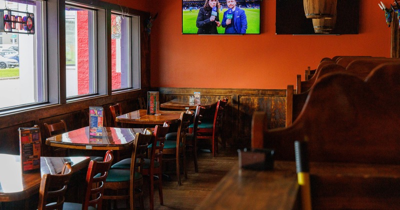 Cozy restaurant interior with orange walls, wooden tables, and chairs