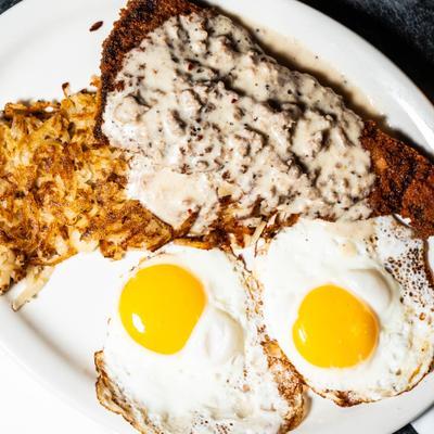 Chicken fried steak with eggs and hash browns.