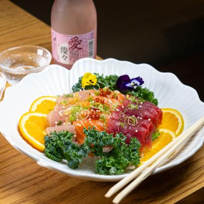 Sashimi platter featuring slices of raw salmon, tuna, yellowtale and garnishes.