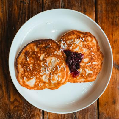 Banana panecakes topped with a berry compote and shredded coconut.