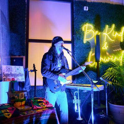 Musician performing on stage with a guitar.