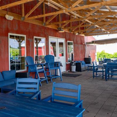 Outdoor, covered patio with tables and chairs.