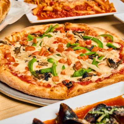 Veggie Pizza topped with fresh green peppers, mushrooms and diced tomatoes.