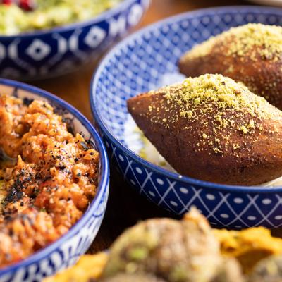 Dish of Kibbeh served on the table alongside other dishes, close-up.