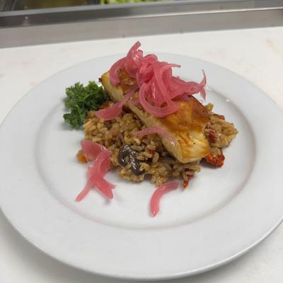 Salmon on mushroom risotto topped with piceled onions.