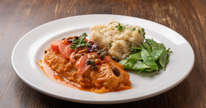 Sauce-topped chicken, served with rice and greens
