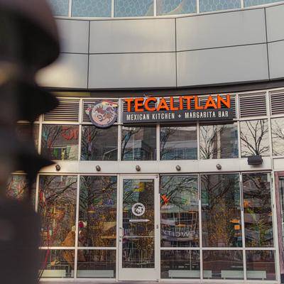Tecalitlan restaurant entrance with signage and large glass windows.
