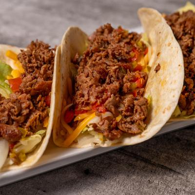 Tacos with ground beef, lettuce, cheese, and tomatoes.