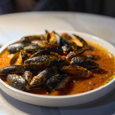 Dish of mussels in a red tomato sauce.