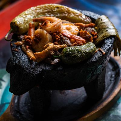 Fajita Molcajete featuring shrimp, sliced steak, chicken, chorizo, cactus and jalapeno.