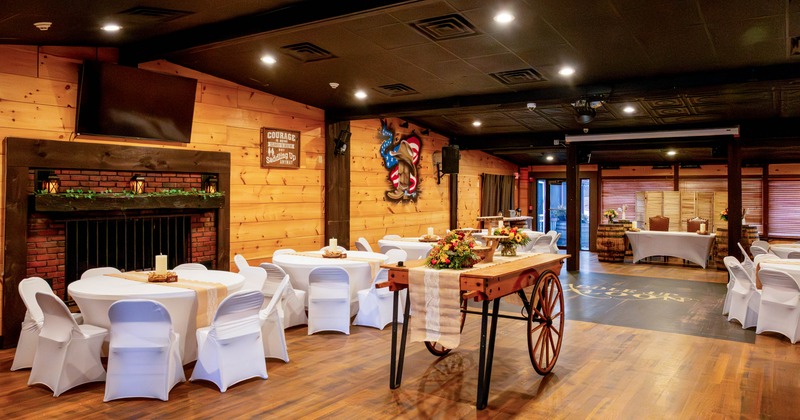 Interior, event area, round white cloth tables for eight people, wood coated walls