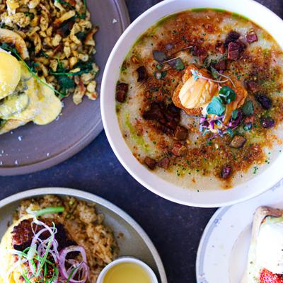 Rice porridge with pork surrounded by other dishes.