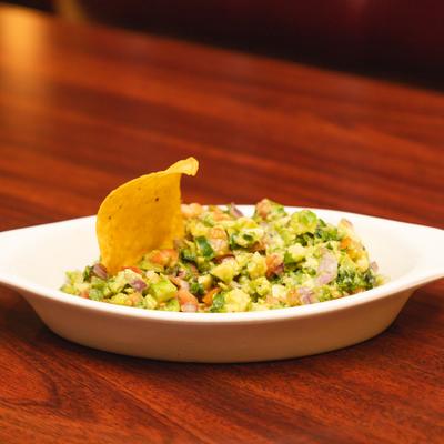 Plate of guacamole served on the table.
